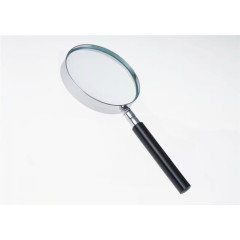 办公用品斜放的黑色放大镜