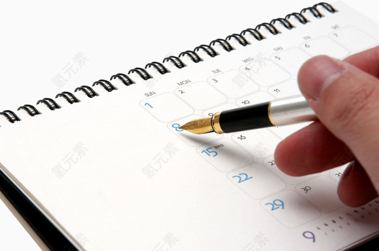 手拿钢笔在台历上记事
